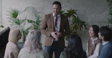 Kendine güveni tam bir iş adamı, farklı gruplardan oluşan ve eğitimden zevk alan insanlarla takım oluşturma egzersizi yapıyor. Koçluk ve başarılı insanlar konsepti.