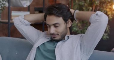 Rahat bir Arap 'ın yavaşça gerilip kanepede oturup akşamları tek başına dinlenmesi. Yaşam tarzı ve insan kavramı.