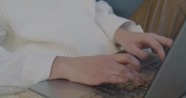 Kanepede oturan kadın bilgisayarını kullanırken dizüstü bilgisayarla çalışan kadın ellerinin yakın çekimi. Teknoloji ve iş konsepti.
