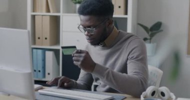 Kredi kartı ve bilgisayar kullanan Afrikalı Amerikalı girişimci, elektronik finansın tadını çıkarıyor. Ofise yatırım yapıyor. Para ve bankacılık kavramı.