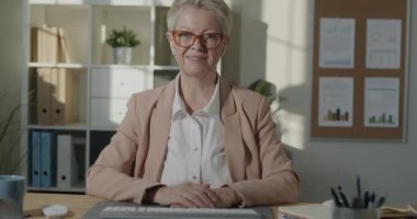 Ofisteki kameraya bakarak el hareketlerinde bulunan, hırslı, olgun bir kadının portresi. İş ve profesyonel iletişim kavramı.