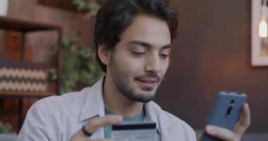 Kaygısız Orta Doğulu biri banka kartı ve akıllı telefonuyla alışveriş yapıyor. Ve akşamları evde plastik kart tutuyor. İnsanlar ve para kavramı.