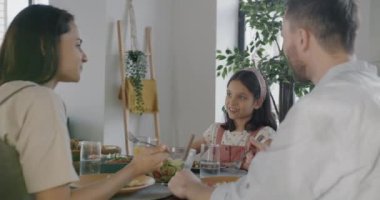 Erkek kadın ve çocuk öğle yemeği yerken mutfakta yemeğin tadını çıkarıyorlar. Aile ilişkisi ve yaşam tarzı kavramı.