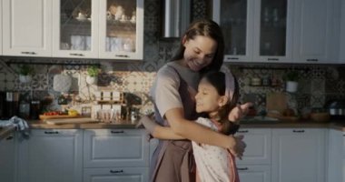 Sevgi dolu bir anne ve kızın sevgi dolu bir ilişkinin tadını çıkarması. Mutfakta durmuş. Aile ve duygu kavramı.