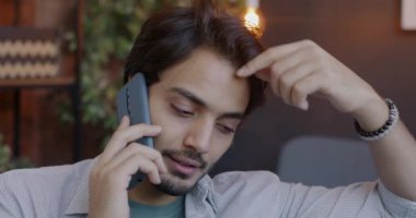 Neşeli Orta Doğulu bir adamın akşamları cep telefonuyla konuşmasının yakın çekimi. İletişim ve yaşam tarzı kavramı.