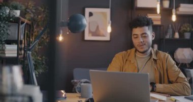 Neşeli Orta Doğulu adam el sallayarak sanal buluşmadan zevk alıyor. Geceleri evde video görüşmesi yapıyor. İnsanlar ve iletişim konsepti.