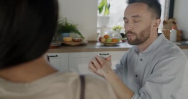 Karı koca, evde yemek yerken su içip sohbet ediyorlar. Aile hayatı ve sağlıklı beslenme konsepti.