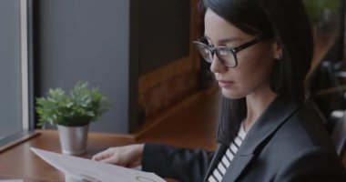 Kendine güvenen iş kadını mali belgeleri kontrol ediyor ve kafede çalışırken kahve içiyor. Hırslı kişi ve mesleki meslek kavramı.