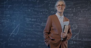 Yaşlı bayan üniversite profesörünün yavaş çekimde portresi karatahta duvarına yaslanmış bir kitapla duruyor. İnsanlar ve bilim konsepti.