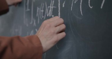 Sınıfta karatahta ile çalışan kadın el yazısı formülüne yakın çekim. Eğitim ve bilgi kavramı.