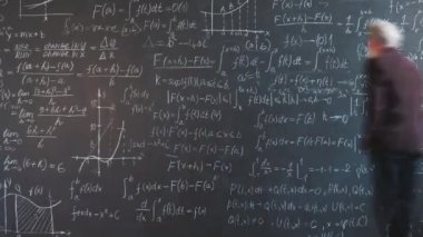 Üniversitede son sınıf profesörünün karatahtaya yazı yazması, sınıfta yürümesi, fen geliştirme bölümünde çalışması. Eğitim ve insanlar kavramı.