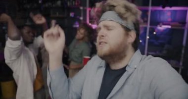 Neşeli genç adam vlogger gece sosyal medyada kamera paylaşımına bakarak parti dansından komik videolar kaydediyor. Gençlik ve vlog konsepti.