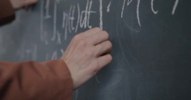 Sınıfta karatahta ile çalışan kadın el yazısı formülüne yakın çekim. Eğitim ve bilgi kavramı.