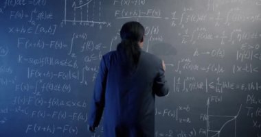 Tebeşir tahtasına yürüyen ve matematik yazan Afro-Amerikan fen öğretmeni sınıfta düşünme formülünü hesaplıyor. Eğitim ve bilgi kavramı.