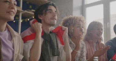 Kanadalı bayraklı genç sporseverler TV 'de yarışma seyrediyor evde eğleniyorlar. Gençlik ve hobi kavramı.