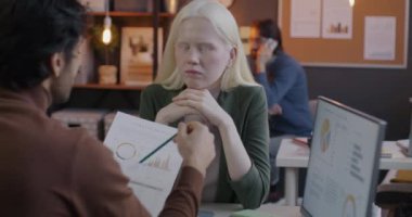 İş kadını, iş arkadaşlarıyla şirket bütçesini tartışıyor ve iş belgesini okuyor. Ofisteki mali analizlere odaklanıyor. Ekonomi ve muhasebe kavramı.