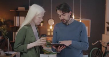 Erkek ve kadın meslektaşlar ofiste duruyor ve iş belgelerini paylaşıyorlar. Özel çalışma alanı ve işbirliği kavramı.