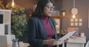 Düşünceli Orta Doğulu işçilerin iş belgelerini okurken yavaş çekimde çekilmiş portresi akşam ofiste kameraya yansıyor. İş ve insanlar kavramı.