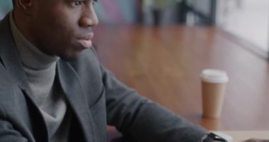 Kafedeki ekrana bakarak dizüstü bilgisayarla çalışan Afrikalı Amerikalı girişimci. İş konsepti için hırslı kişi ve modern teknoloji.