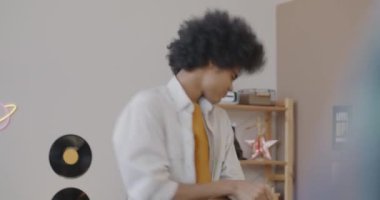 Mutlu Afro-Amerikan ergen çocuk müzik eşliğinde dans ederek evde boş vakitlerin tadını çıkarıyor. Aktif yaşam tarzı ve gençlik kültürü kavramı.