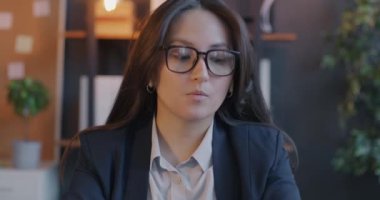 Genç iş kadınının portresi müşteriyle çevrimiçi görüşmeler yapıyor kameraya bakıyor ve ofiste konuşuyor. İletişim ve iş konsepti.