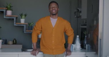 Genç Afrikalı Amerikalı bir adam mutfakta dikilirken kız arkadaşı beyaz bir kadın gelip kameraya sarıldı. İlişki ve insan kavramı.