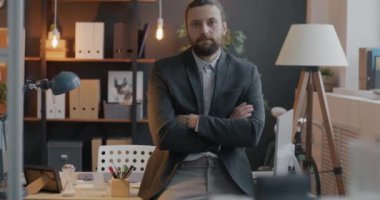 İş yerinde kameraya bakıp kariyer geliştirmeye odaklanmış hırslı bir gencin yavaş çekim portresi. İş ve mesleki meslek kavramı.