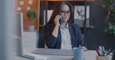 Kendine güvenen iş kadını cep telefonuyla konuşuyor ofiste iş hakkında konuşuyor. Profesyonel iletişim ve iş kavramı.