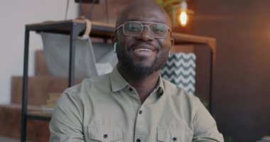 Afrika kökenli Amerikalı iş adamının portresi kameraya bakıyor sanal toplantıda el sallayarak konuşuyor ofiste çevrimiçi video görüşmesi yapıyor. İletişim ve iş konsepti.
