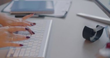 Ofiste çalışan iş kadını rapor verirken, kadın ellerinin kablosuz bilgisayar klavyesiyle daktilo yazışlarını yakından çek. İş ve bilgisayar kavramı.