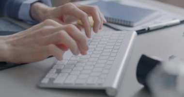 Ofisteki kişisel bilgisayarla çalışan bir iş kadını olarak, kadın çalışanların, kablosuz klavye kullanarak daktilo kullanmalarına yakın çekim. İş ve teknoloji kavramı.