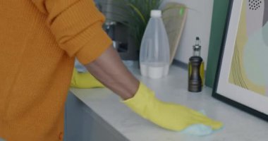 Erkek elleri lastik eldivenlerle mutfak masasını temizlerken dairede ev işleri yaparken. Hijyen ve temizlik konsepti.