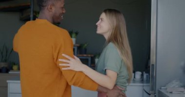 Güzel, melez bir çift mutfakta dans ediyor ve evde romantik bir ilişki yaşıyor. İlişki ve eğlence etkinliği kavramı.