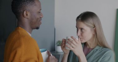 Neşeli genç insanlar çay içip sohbet ediyorlar ve sabah evde birlikte eğleniyorlar. Olumlu duygu ve ilişki kavramı.