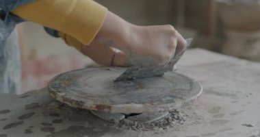 Atölyedeki geleneksel aletleri kullanarak kadın el temizleme tekerine yakın çekim. Çömlek aktivitesi ve enstrüman konsepti.