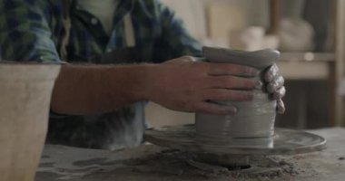 Masada çark kullanarak vazo yapan erkek elleri yavaş çekimde. Yaratıcı meslek ve el yapımı mallar kavramı.