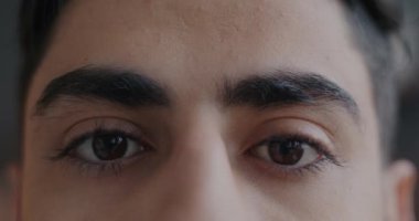 Kameraya bakan Orta Doğulu bir adamın karanlık gözlerinin yavaş çekim portresi. Yüz ifadesi ve duygu konsepti.