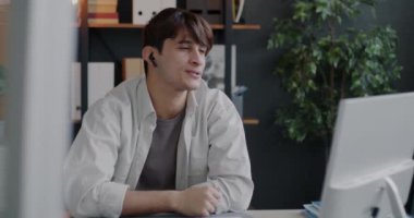 Orta Doğulu bir adam bilgisayar ve kulaklıkla telefonda el sallayarak video konferansı yapıyor. İletişim ve iş insanları kavramı.