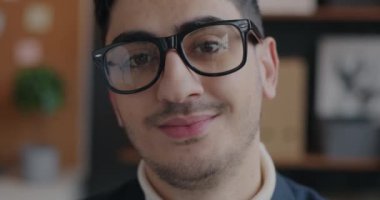 Ofisteki kameraya bakan kendinden emin Orta Doğulu iş adamının yavaş çekim portresi. İş ve insan kavramı.