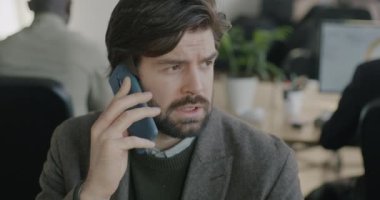 Cep telefonuyla konuşan erkek çalışanın iş görüşmesi ofisteki cep telefonu iletişimine odaklandı. İş adamı ve işyeri konsepti.