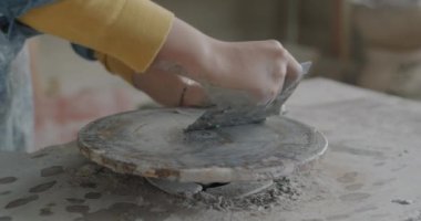 Atölyedeki geleneksel aletleri kullanarak kadın el temizleme tekerine yakın çekim. Çömlek aktivitesi ve enstrüman konsepti.