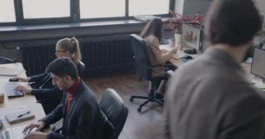 Masalarda çalışan bir grup insanla yoğun çalışma merkezinin yüksek açılı görüntüsü. Ofis çalışanları ve başarılı iş konsepti.