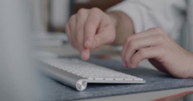 Kablosuz bilgisayar klavyesini kullanarak elleri yakın çekimde kapalı alanda bulanık arka plana karşı yazarak. Modern teknoloji ve iş kavramı.