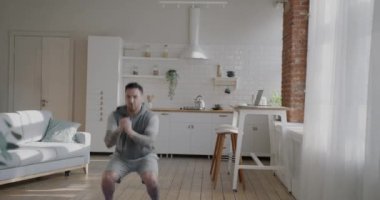 Genç motivasyonlu sporcu evde antrenman yapıyor. Egzersiz yapıyor. Egzersiz yapıyor. Aktif yaşam tarzı ve insanların konsepti.
