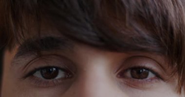 Orta Doğulu bir adamın duygusuz bir şekilde kameraya bakan güzel kahverengi gözlerinin yakın plan portresi. Yüz ifadesi ve insanların konsepti.