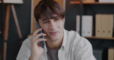 Orta Doğulu bir adam cep telefonuyla konuşuyor. Ofiste iş hakkında konuşuyor. Cep telefonu iletişimi ve iş dünyası kavramı.
