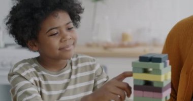 Mutlu Afro-Amerikan çocuk evde ebeveynleriyle güzel ahşap oyuncaklarla oynuyor. Çocukluk ve eğlenceli aktivite konsepti.