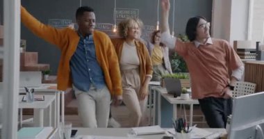 Bir grup neşeli iş adamı yaratıcı ofiste gülüp eğleniyor. İş eğlencesi ve mutlu çalışanlar konsepti.