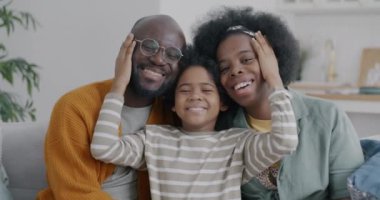 Neşeli Afro-Amerikan aile portresi. Anne ve çocuk kameraya bakıp gülüyorlar. Evde sevgi ve ilgi gösteriyorlar. İnsanlar ve olumlu duygu kavramı.