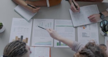 İş adamlarının üst düzey görüşü, ofiste iş geliştirmeyi tartışan belgelere işaret ediyor. Belgeler ve iş kavramı.